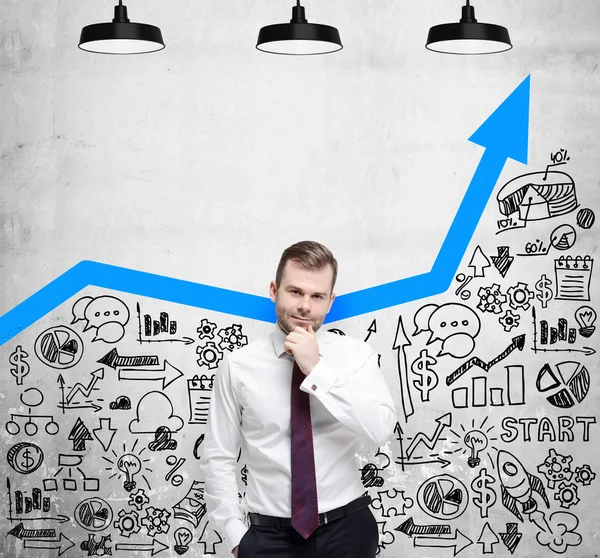 O empresário está à procura de novas ideias de negócio. Flecha azul crescente como um conceito de negócio bem sucedido. Ícones de negócios são desenhados na parede de concreto . — Fotografia de Stock