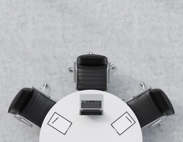 Vista superior de la mitad de la sala de conferencias. Una mesa redonda blanca, tres sillas de cuero negro. Un portátil con almohadillas legales están sobre la mesa. Interior de oficina. Renderizado 3D . — Foto de Stock