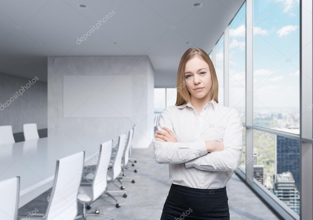 Young beautiful business lady with crossed hands in the panoramic meeting room with huge windows and New York City view.