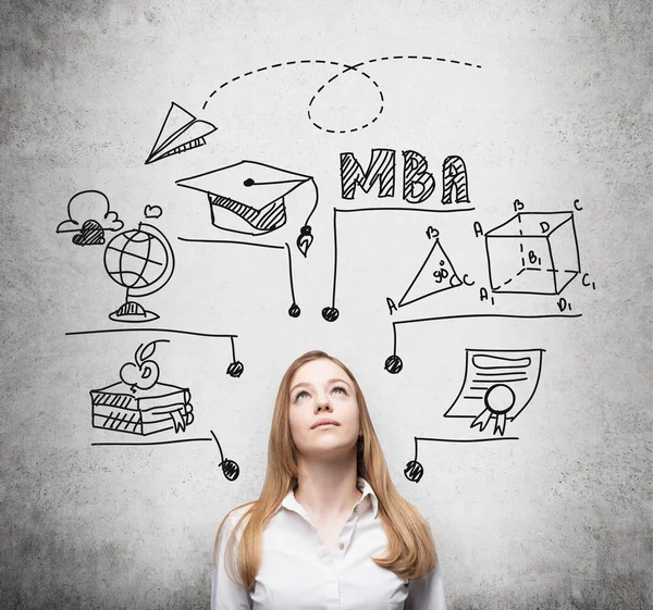 A young lady is thinking about MBA degree. Educational chart is drawn behind her. A concept of further business education. Concrete background. — Stock Fotó