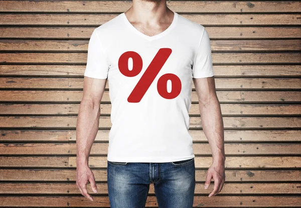 Close up of the body view of the man in a white t-shirt with the red percentage sign on the chest. Wooden wall on the background. — Stock Photo, Image