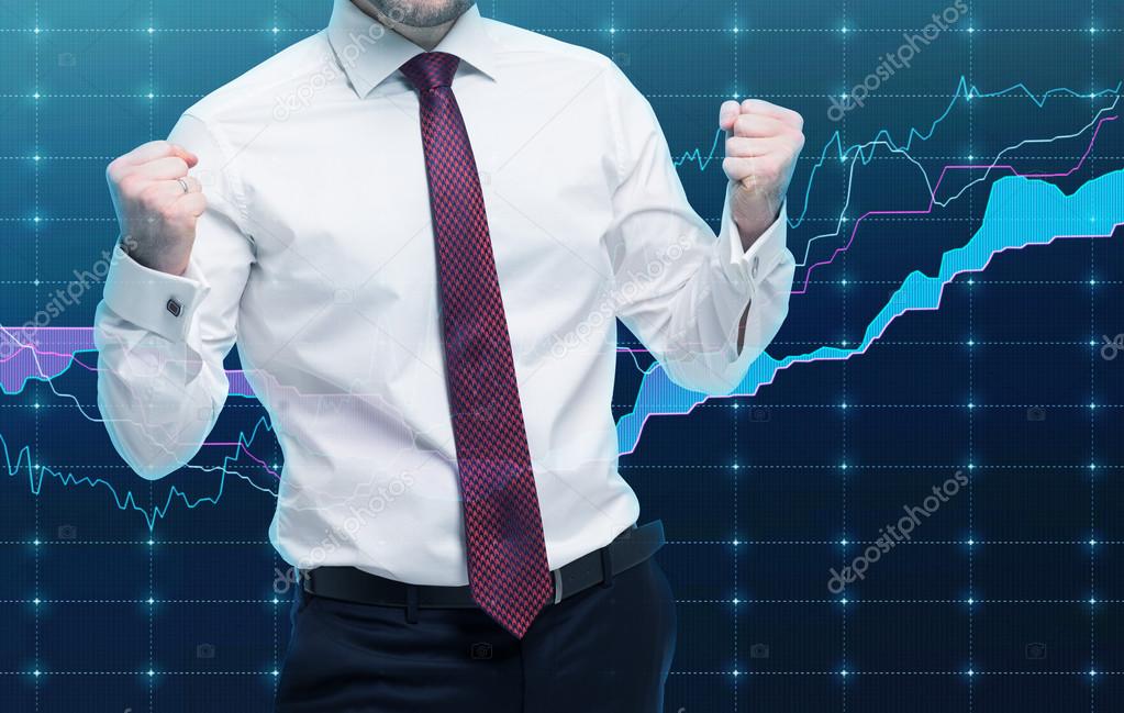 Closeup of successful portfolio manager in white shirt with pumped fists. A concept of the celebrating of success. Forex chart on the background.