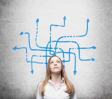 A beautiful young lady is pondering about possible solutions of the complicated problem. Many blue arrows with different directions are drawn around her head. Concrete wall as a background. clipart