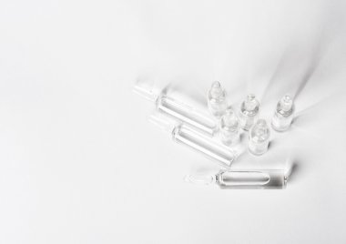 Top view of break-seal glass ampoule set with liquid medicine on white background.
