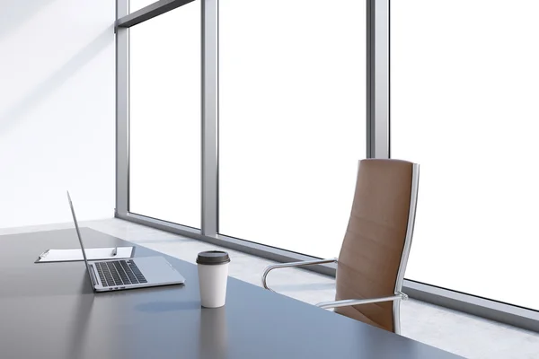 Ein Arbeitsplatz in einem modernen Panoramabüro mit Kopierraum in den Fenstern. ein grauer Tisch, brauner Lederstuhl. Laptop, Schreibblock und eine Kappe Kaffee stehen auf dem Tisch. Büroinnenraum. 3D-Darstellung. — Stockfoto