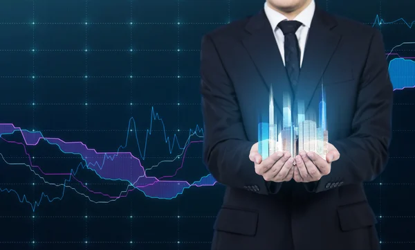 Egy személy birtokolja egy hologram, felhőkarcolók, mint egy szimbólum, a pénzügyi siker. Elöl levő térképez a háttérben. — Stock Fotó
