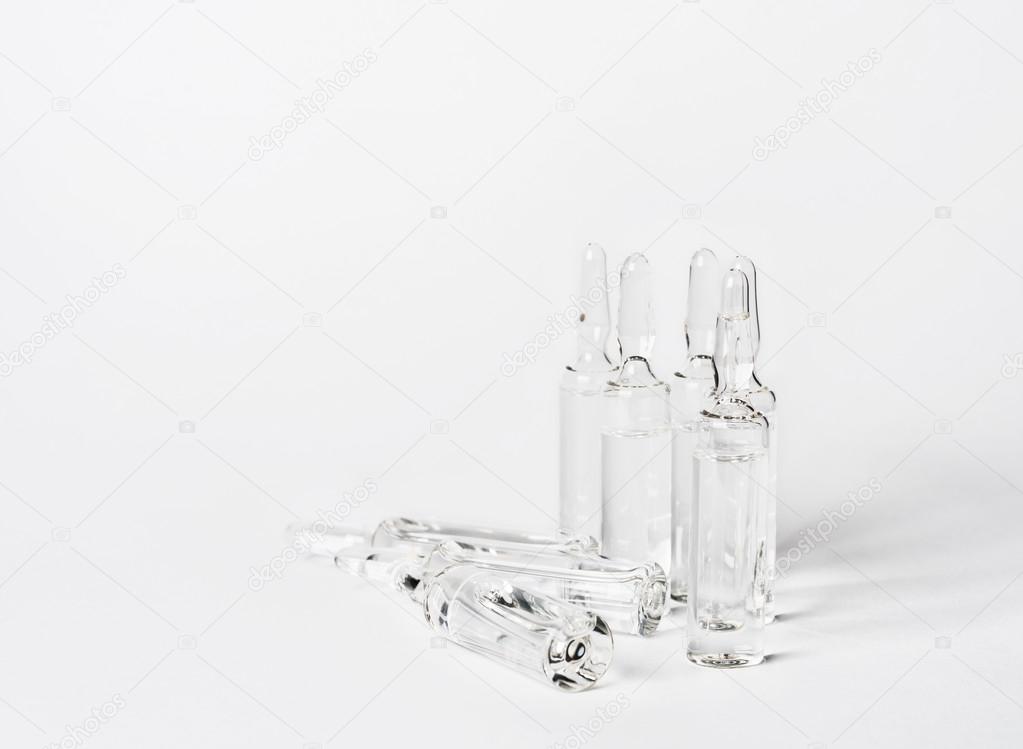 Break-seal glass ampoule set with liquid medicine on white background.