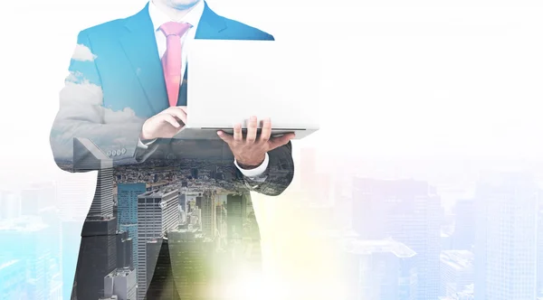 A transparent silhouette of a man in formal suit who is looking for some data in the laptop. Panorama of New York city on the background. — Stockfoto