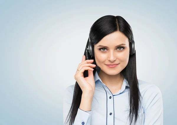 Vista frontal da morena sorridente telefonista de apoio com fone de ouvido. Isolado sobre fundo branco . — Fotografia de Stock
