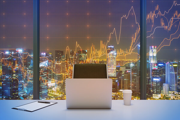 A workplace in a modern panoramic office with New York evening view and financial chart over the window. Laptop, writing pad and a cap of coffee are on the table. Office interior. 3D rendering.