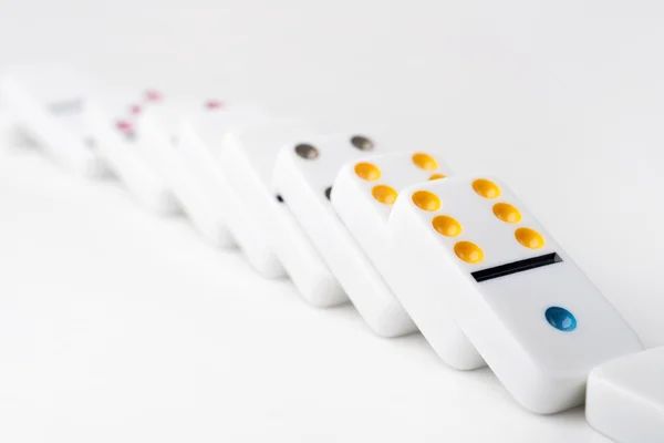 The domino effect of white blocks, with colorful numbers. Selective focus on the front part of the domino blocks. White Background. — Φωτογραφία Αρχείου