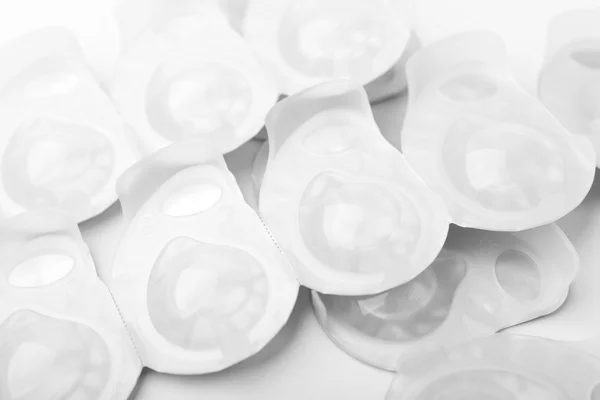Several packs of contact lens on white surface. — Stockfoto