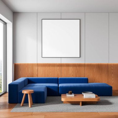 Modern interior with blue sectional sofa, blank poster on wall mockup, wooden panels and furniture, gray carpet, bright background. 3D Rendering