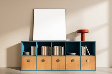 Blank poster mockup leaning on blue storage cabinet with wooden drawers, books, and red lamp in modern minimalist interior on beige wall. 3D Rendering