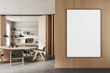 Vertical poster mockup on wooden wall in contemporary office interior with round table, green chairs, and built-in shelf in background. 3D Rendering