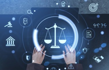 Hands typing on keyboard with glowing justice scale hologram and law-related icons on abstract dark background, concept of digital legal technology