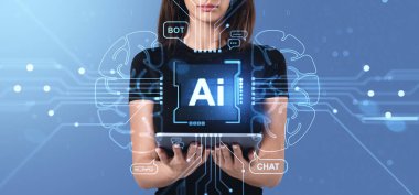 Parlak yapay zeka arayüzü, fütüristik beyin ve mavi arka planda teknoloji tarzı sohbet simgeleri, sanal yardım ve hologram kavramına sahip bir kadın elinde tablet tutuyor.
