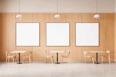Modern kafenin içinde, ahşap mobilya ve kolye ışıkları sergilenen, markalaştırma veya ürün konsepti olan üç boş poster modeli. 3B Hazırlama