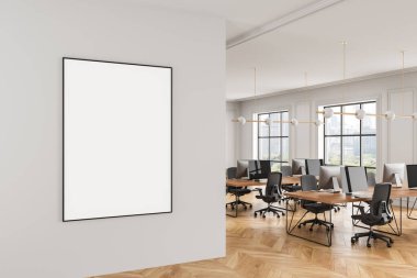 Modern ofis içi, ahşap döşemeli, parlak ışıklandırmalı ve bilgisayarlı beyaz duvarda çerçevelenmiş boş poster modeli. Markalaşma düzeni için 3B Hazırlama
