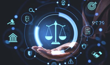 Adalet ölçeğinin gelecekteki hologramı açık el üstünde yasal simgelerle çevrili, koyu arka planda parlayan, modern hukuk kavramını sembolize eden