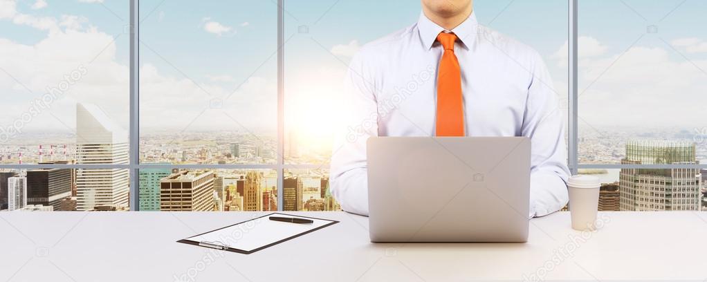 Young businessman is working with the laptop. Modern Panoramic office or work place with New York city view.