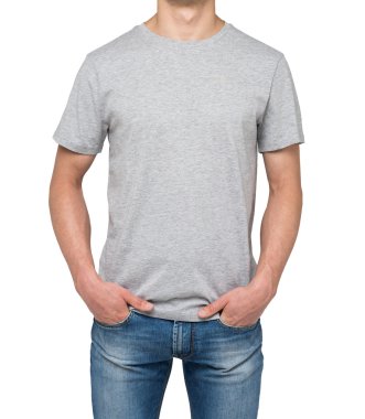 A man in a grey t-shirt and denims holds his hands in pockets. Isolated on white.
