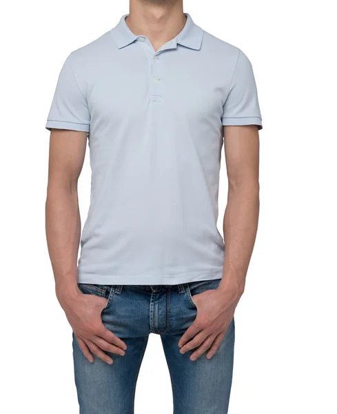 A man in a light blue polo shirt and denims holds his hands in pockets. Isolated on white. — Stock Photo, Image