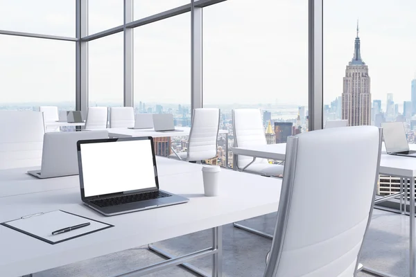 Posti di lavoro in un angolo moderno ufficio panoramico a Manhattan, New York City. Tavoli bianchi e sedie bianche. Un computer portatile con schermo bianco, blocco note e una tazza di caffè. Rendering 3D . — Foto Stock