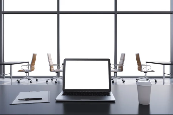 Vue de face sur le lieu de travail dans un bureau panoramique moderne avec espace de copie dans les fenêtres. Tables noires et chaises brunes. Un ordinateur portable avec un écran blanc, un bloc-notes et une tasse à café. rendu 3D . — Photo