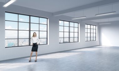 A full length woman in formal clothes who is looking out the window, New York panoramic view. A modern loft style open space.
