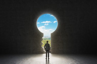 A keyhole in the concrete wall. A businessman dressed in formal suit is looking at New York City in the hole.