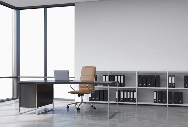 A workplace in a modern corner panoramic office with copy space in the windows. A black desk with a laptop, brown leather chair and a bookshelf with black document folders. 3D rendering. — Stock Photo, Image
