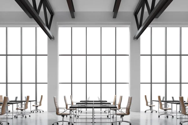 Modern workplaces in a modern bright clean interior of a loft style office. Huge windows with copy space and white walls. Black desks equipped with laptops, brown leather chairs. 3D rendering. — Stock Photo, Image