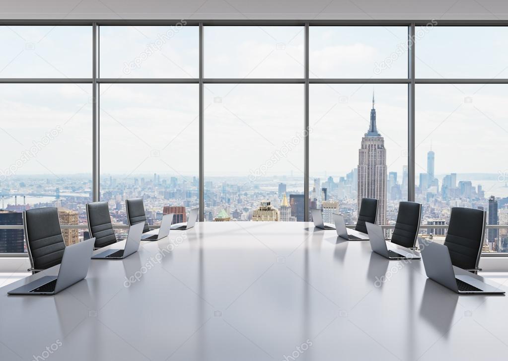 A conference room equipped by modern laptops in a modern panoramic office in New York. Black leather chairs and a white table. 3D rendering.