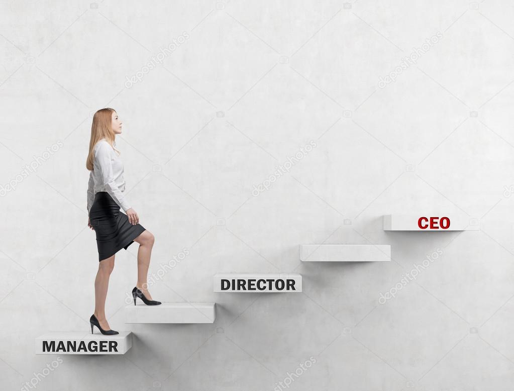 A young business lady is going up the corporate ladder from the manager to CEO. Concrete background.