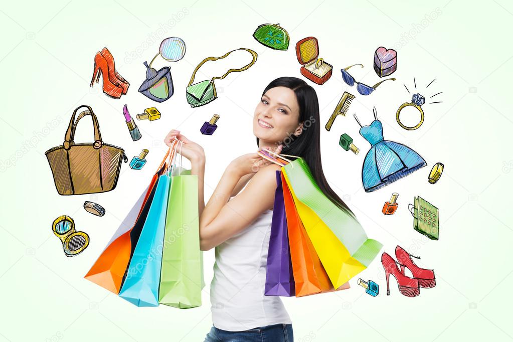 Beautiful smiling young woman with the colourful shopping bags from the fancy shops. Light green background with drawn shopping icons.