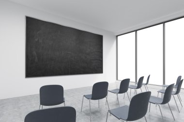 A classroom or presentation room in a modern university of fancy office. Black chairs, panoramic windows with white copy space and a black chalkboard on the wall. 3D rendering.