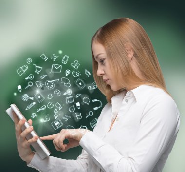 Side view of a business lady in formal clothes who is browsing some information in the book. Social media icons are flying in the air.