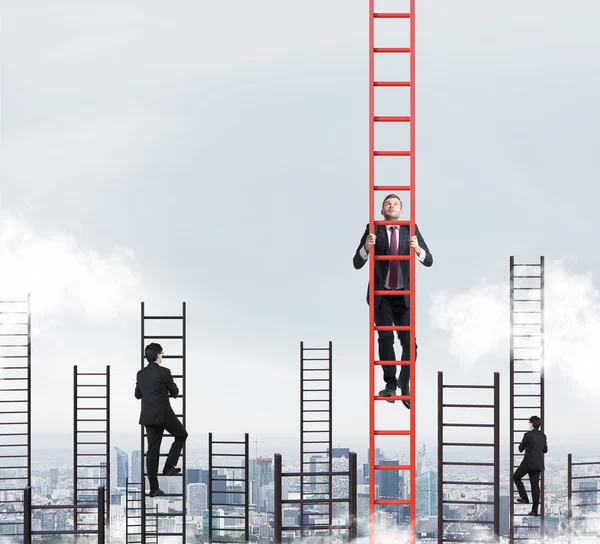 A concept of competition, and problem solving. Several businessmen are racing to achieve the highest point using ladders. New York city view. — Stock Photo, Image