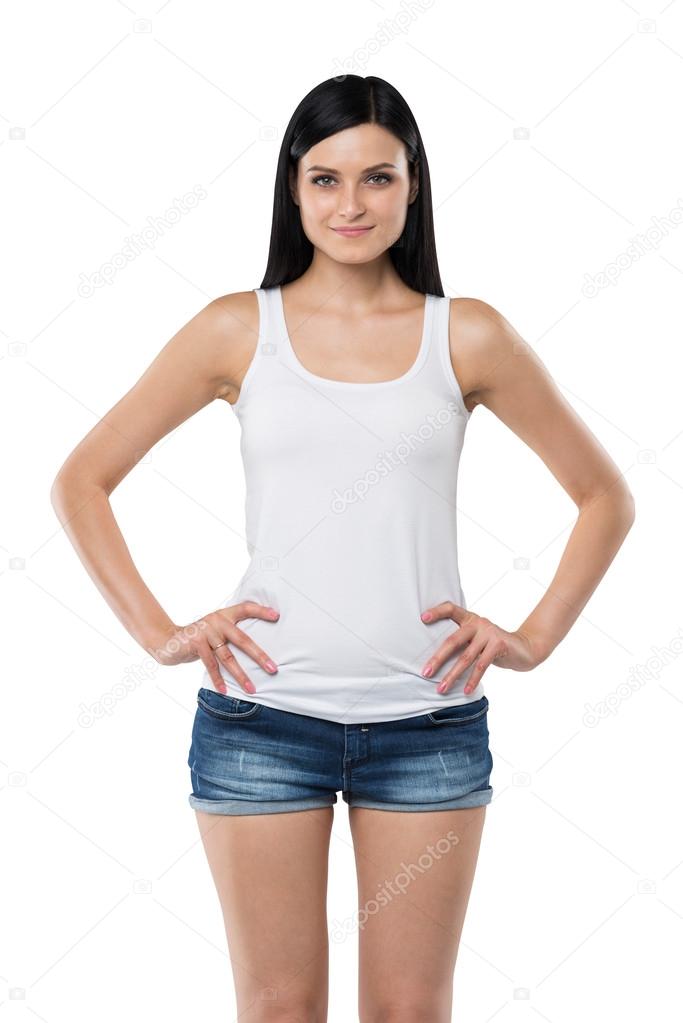 Brunette woman is in a white tank top and blue denim shorts. isolated.