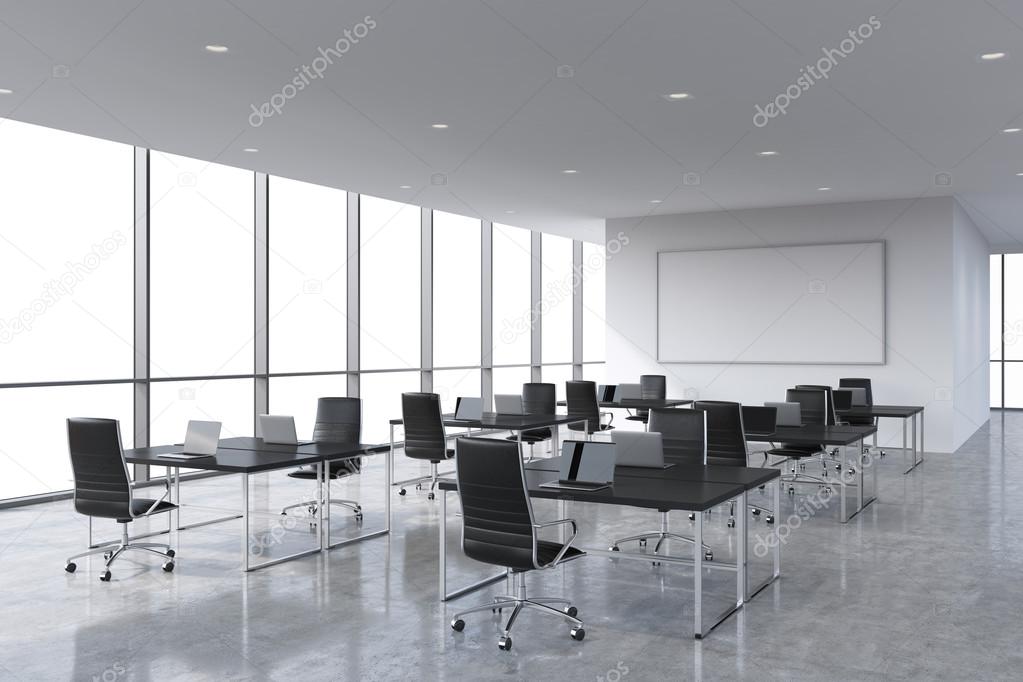 Corporate workplaces equipped by modern laptops in a modern panoramic office, white copy space in the windows. Black leather chairs and a black tables, a huge whiteboard on the wall. 3D rendering.