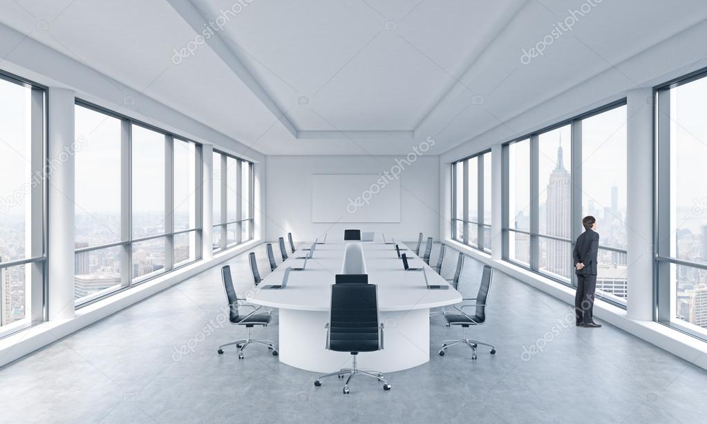 A Businessman Is Looking Out The Window In A Modern