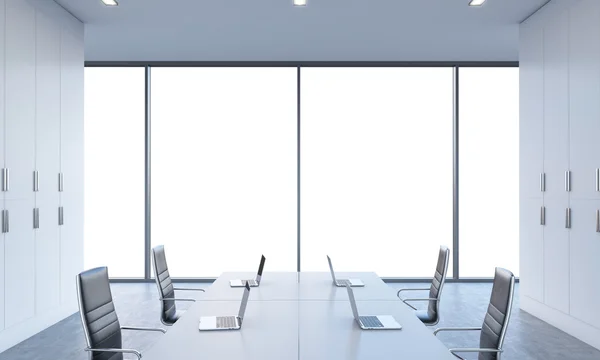 Arbeitsplätze oder Konferenzbereich in einem hellen, modernen Großraumbüro. weiße Tische mit modernen Laptops und schwarzen Stühlen. weißen Kopierraum in den Panoramafenstern. 3D-Darstellung. — Stockfoto