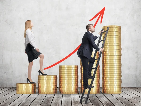 A woman in formal clothes is going up through a stairs which are made of golden coins, while a man has found a shortcut how to reach the final point. A concept of success. Concrete wall and wooden flo — Stock Photo, Image