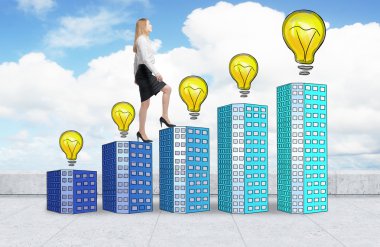 A woman in formal clothes is going up using a stairs which are made of houses with lightbulbs. A concept of new ideas and success. Concrete roof and cloudy sky.