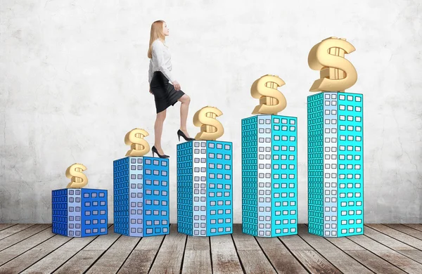 A woman in formal clothes is going up using a stairs which are made of houses. A concept of success. Dollar signs are on each building. — Stock Fotó