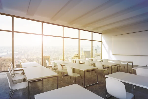 A modern panoramic classroom with New York view. White tables and white chairs. 3D rendering. Sunset. Toned image. — Stock Photo, Image