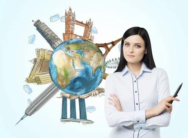 A beautiful brunette woman with mark pen and a globe with sketched famous touristic places in the world. Elements of this image furnished by NASA. — Stock Fotó