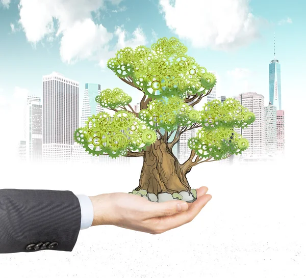 A hand in formal suit holds a sketched tree on the palm. A concept of the process of a growing business or a start up. A sketch of New York city is on background. — 图库照片