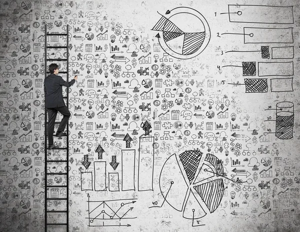 Ein Geschäftsmann auf der Leiter zeichnet Geschäftsikonen und Schautafeln an die Betonwand. — Stockfoto